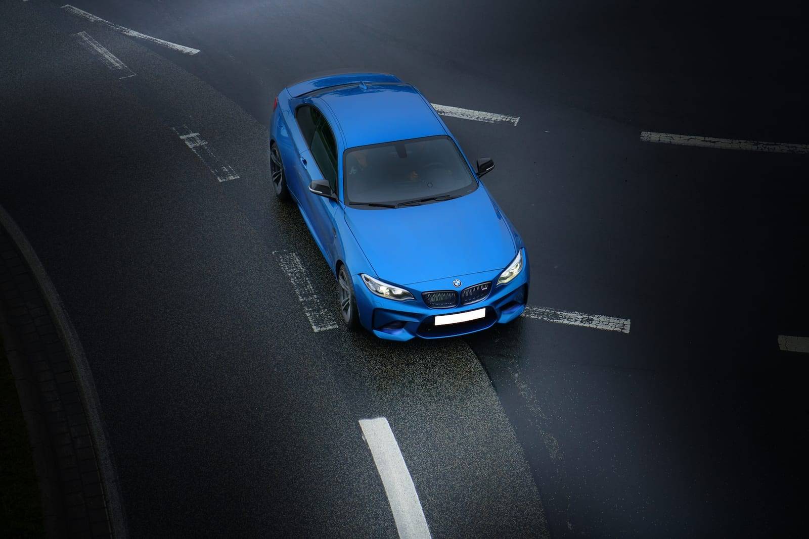 Plavi BMW u vožnji, snimljen odozgo