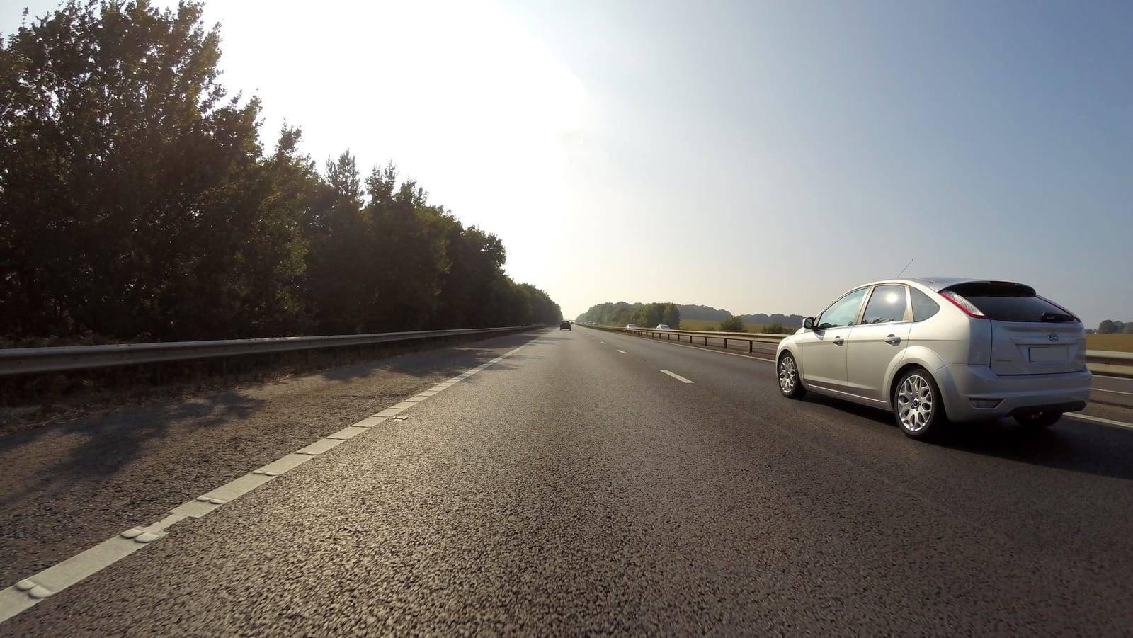 Automobil na otvorenoj cesti pri zalasku sunca